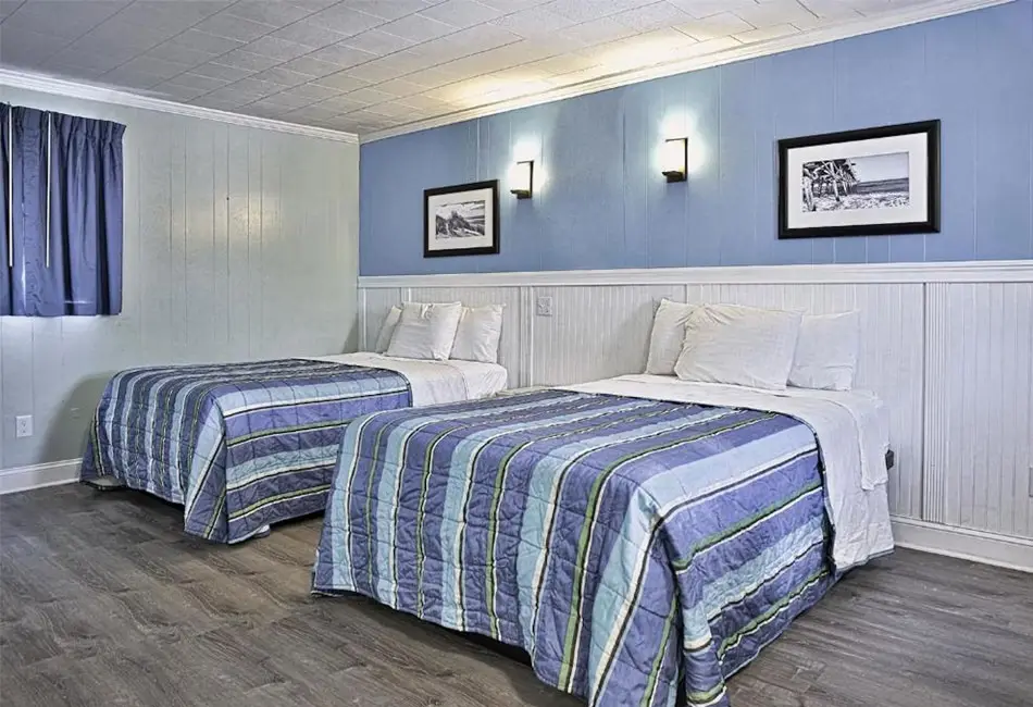 Bedroom with two double beds in a two-bedroom apartment at Colonial Inn