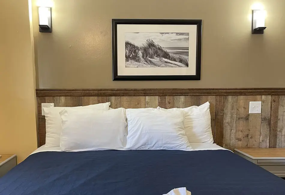 King bed with a navy cover in an oceanfront room at Colonial Inn